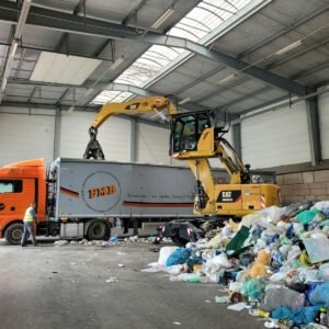 a large truck with a load of trash in a warehouse
