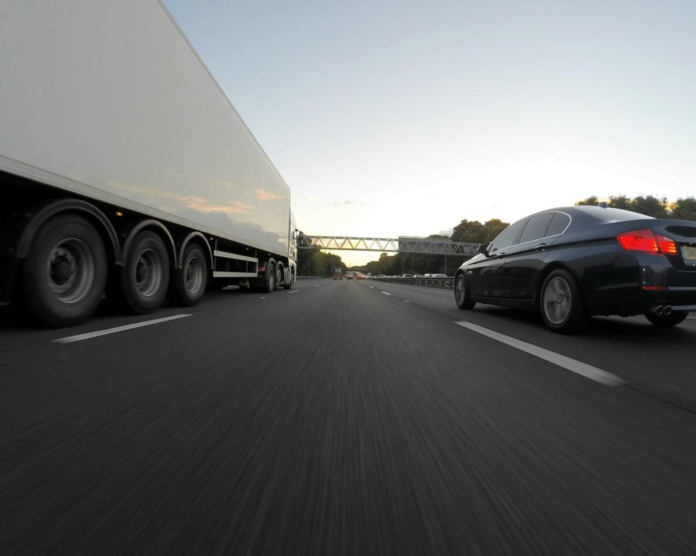 Photo by Mike Bird https://www.miteco.gob.es/es/calidad-y-evaluacion-ambiental/temas/gestion-de-residuos/residuos-no-peligrosos.aspx - Cars and a truck speed along a highway under the clear sky, showcasing transportation dynamics.